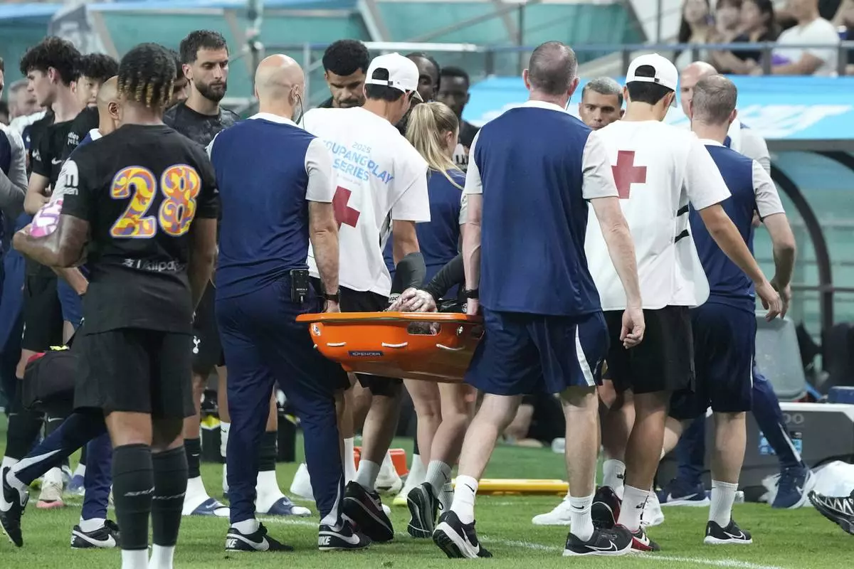 Tottenham Hotspur's James Maddison, center, is carried off the pitch by medical staff after being injured during a preseason friendly soccer match against Newcastle United at Seoul World Cup Stadium in Seoul, South Korea, Sunday, Aug. 3, 2025. (AP Photo/Ahn Young-joon)