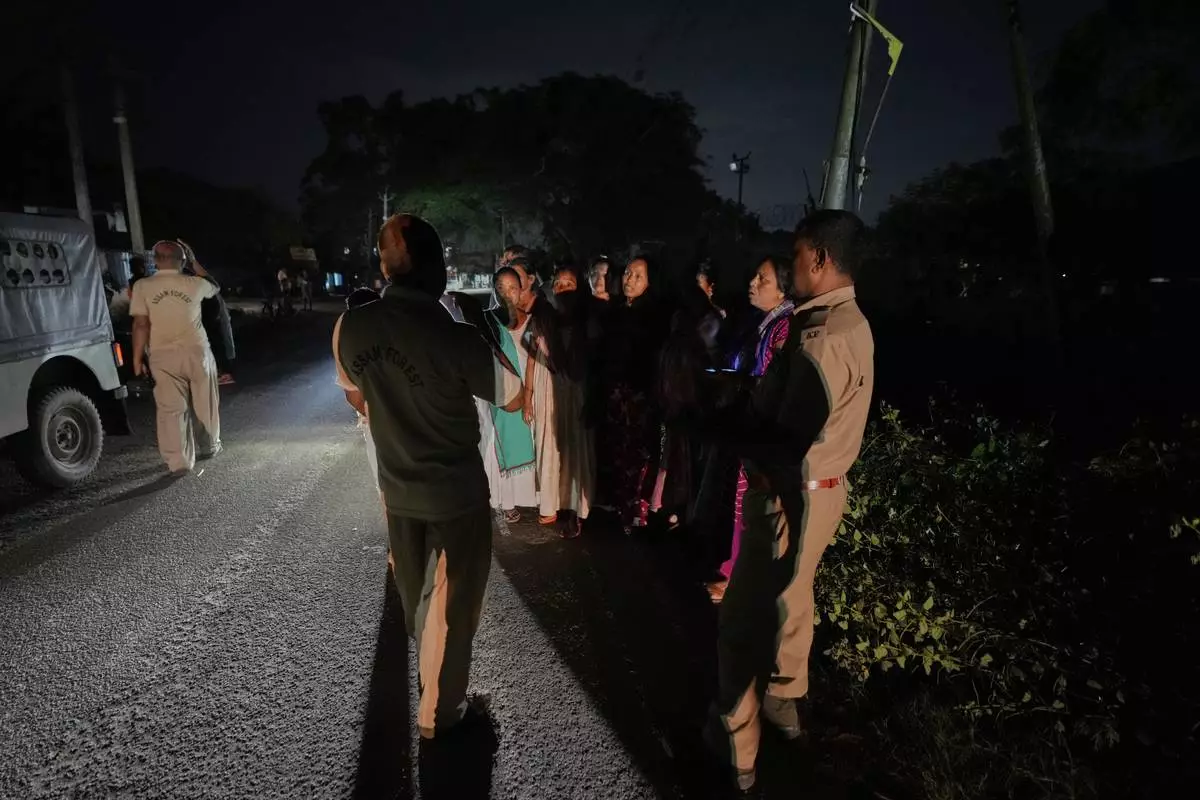 Residents complain to forest officers about the presence of an injured male tusker in their neighborhood, near Amchang wildlife sanctuary on the outskirts of Guwahati, Saturday, Aug. 9, 2025. (AP Photo/Anupam Nath)