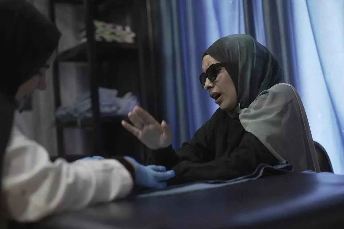 Sarah Jaffal, 21, who was wounded in the pagers attack carried out by Israel on September 17, 2024, reacts during a therapy session at a rehabilitation center in the southern port city of Tyre, Lebanon, Wednesday, May 28, 2025. (AP Photo/Hassan Ammar)