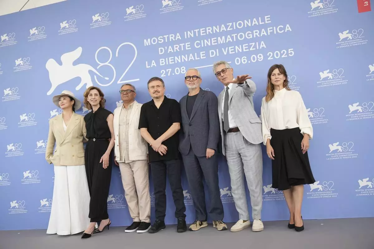 Jury president Alexander Payne, sixth from left, and jury members Zhao Tao, from left, Fernanda Torres, Mohammad Rasoulof, Cristian Mungiu, Stephane Brize and Maura Delpero pose for photographers at the Jury photo call during the 82nd edition of the Venice Film Festival in Venice, Italy, on Wednesday, Aug. 27, 2025. (Photo by Alessandra Tarantino/Invision/AP)