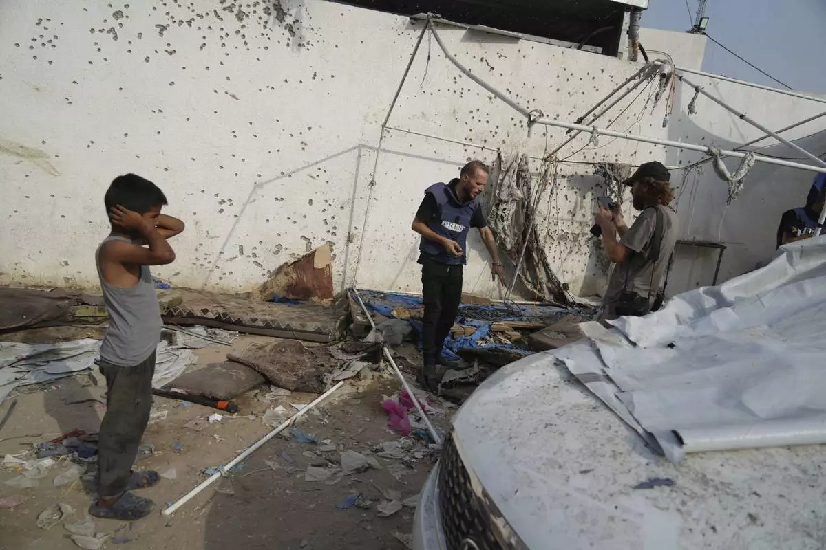 Palestinians inspect the destroyed tent where journalists, including Al Jazeera correspondents Anas al-Sharif and Mohamed Qureiqa, were killed by an Israeli airstrike outside the Gaza City's Shifa hospital complex Monday, Aug. 11, 2025. (AP Photo/Jehad Alshrafi)