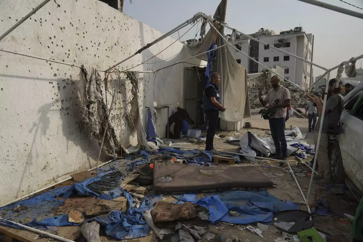 Palestinian inspect the destroyed tent where journalists, including Al Jazeera correspondents Anas al-Sharif and Mohamed Qureiqa, were killed by an Israeli airstrike outside the Gaza City's Shifa hospital complex Monday, Aug. 11, 2025. (AP Photo/Jehad Alshrafi)