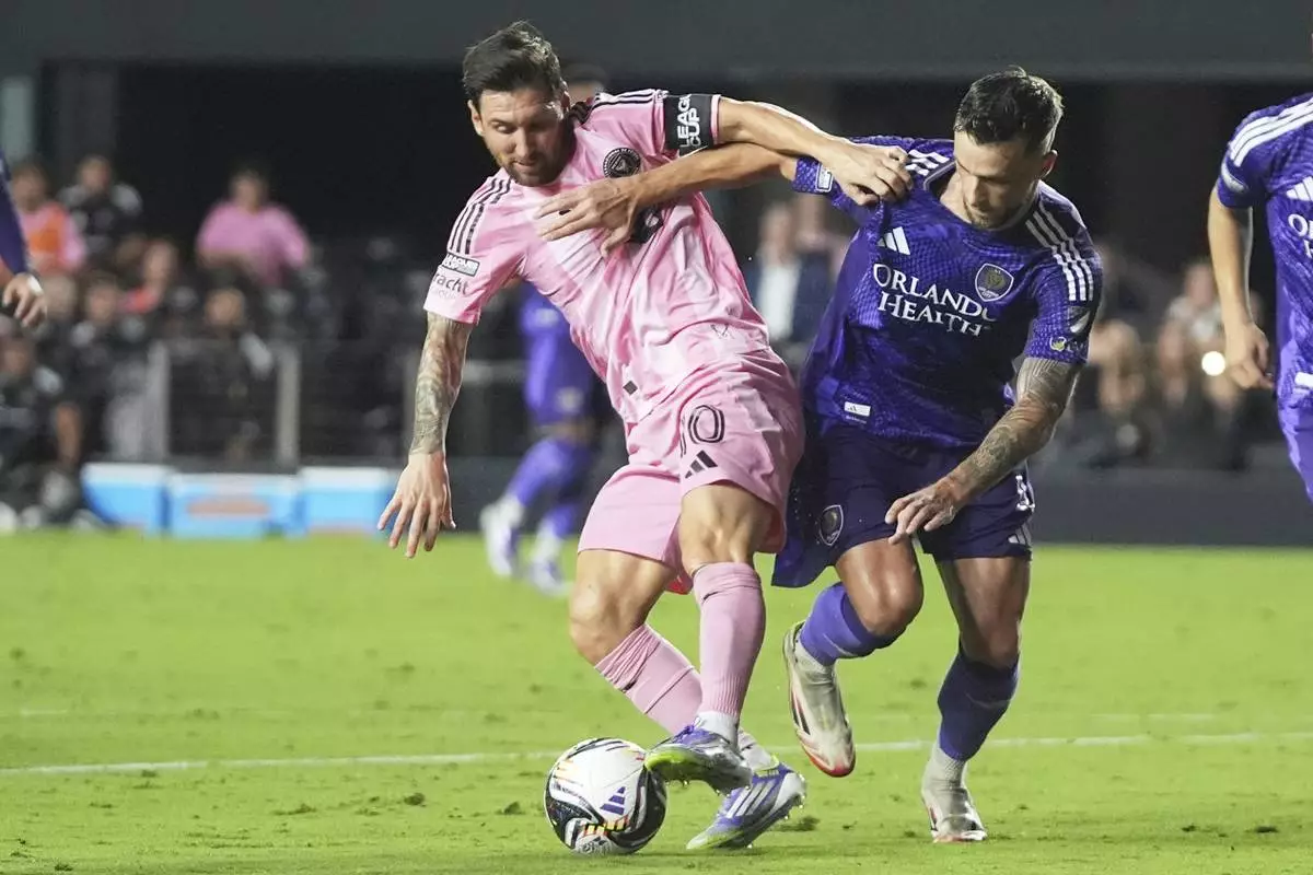 Inter Miami forward Lionel Messi, left, fights for control of the ball against Orlando City defender David Brekalo, right, during the second half of a Leagues Cup semifinal soccer match, Wednesday, Aug. 27, 2025, in Fort Lauderdale, Fla. (AP Photo/Lynne Sladky)