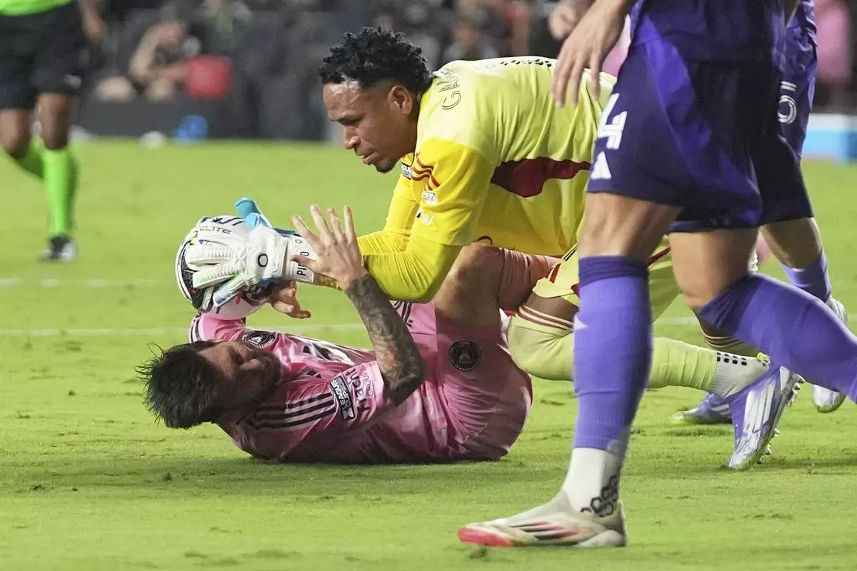 Inter Miami forward Lionel Messi, left, collides with Orlando City goalkeeper Pedro Gallese, right, during the second half of a Leagues Cup semifinal soccer match, Wednesday, Aug. 27, 2025, in Fort Lauderdale, Fla. (AP Photo/Lynne Sladky)