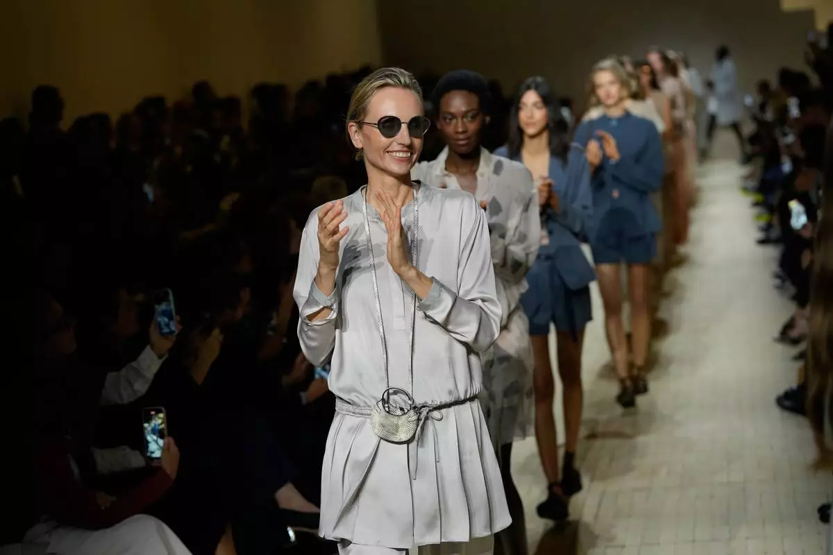 Models clap their hands as they wear creations part of the Emporio Armani women's Spring-Summer 2026 collection, presented in Milan, Italy, Thursday, Sept. 25, 2025. (AP Photo/Luca Bruno)