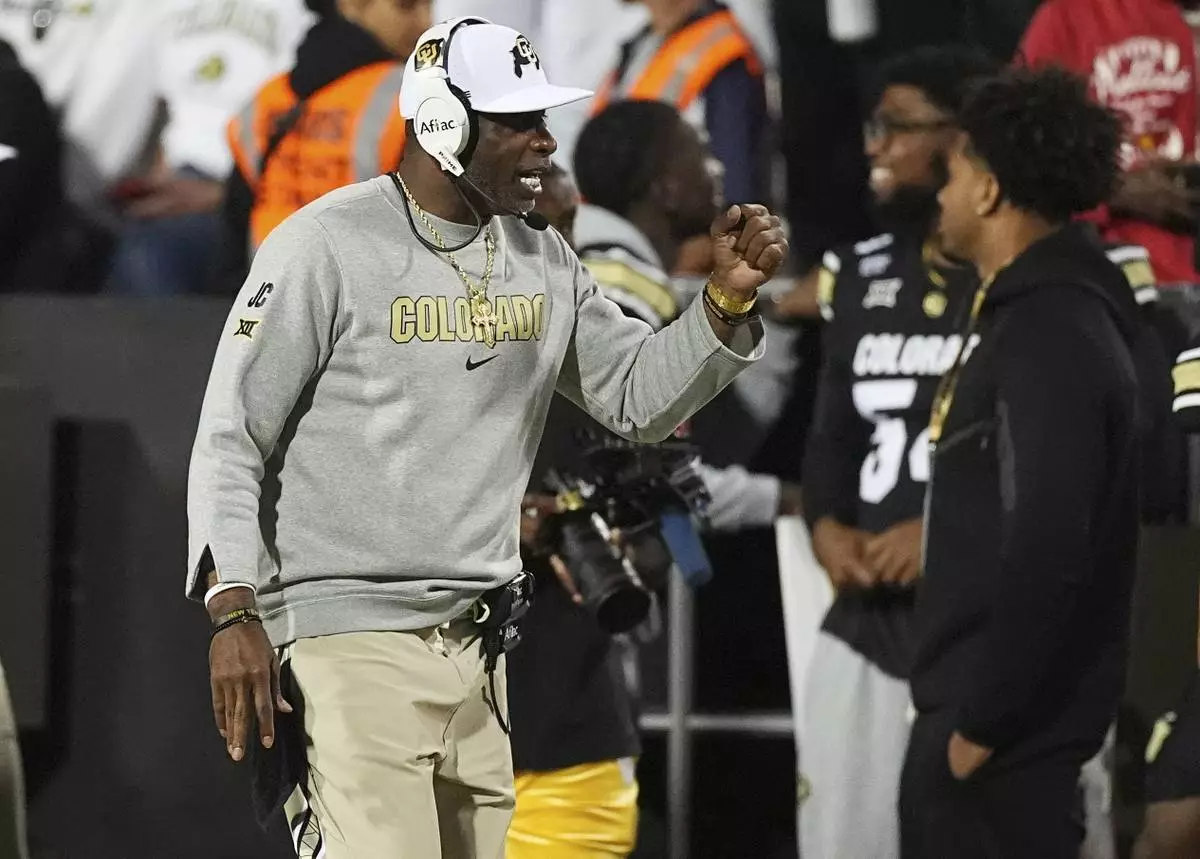 Colorado head coach Deion Sanders, left, directs his players in the first half of an NCAA college football game against Wyoming, Saturday, Sept. 20, 2025, in Boulder, Colo. (AP Photo/David Zalubowski)