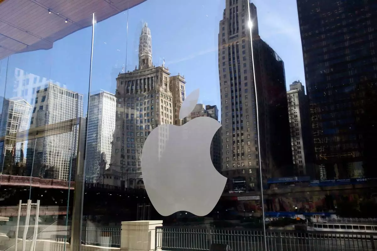 FILE - Buildings are reflected behind the logo at an Apple Store, in downtown Chicago, Oct. 19, 2017. (AP Photo/Kiichiro Sato, File)