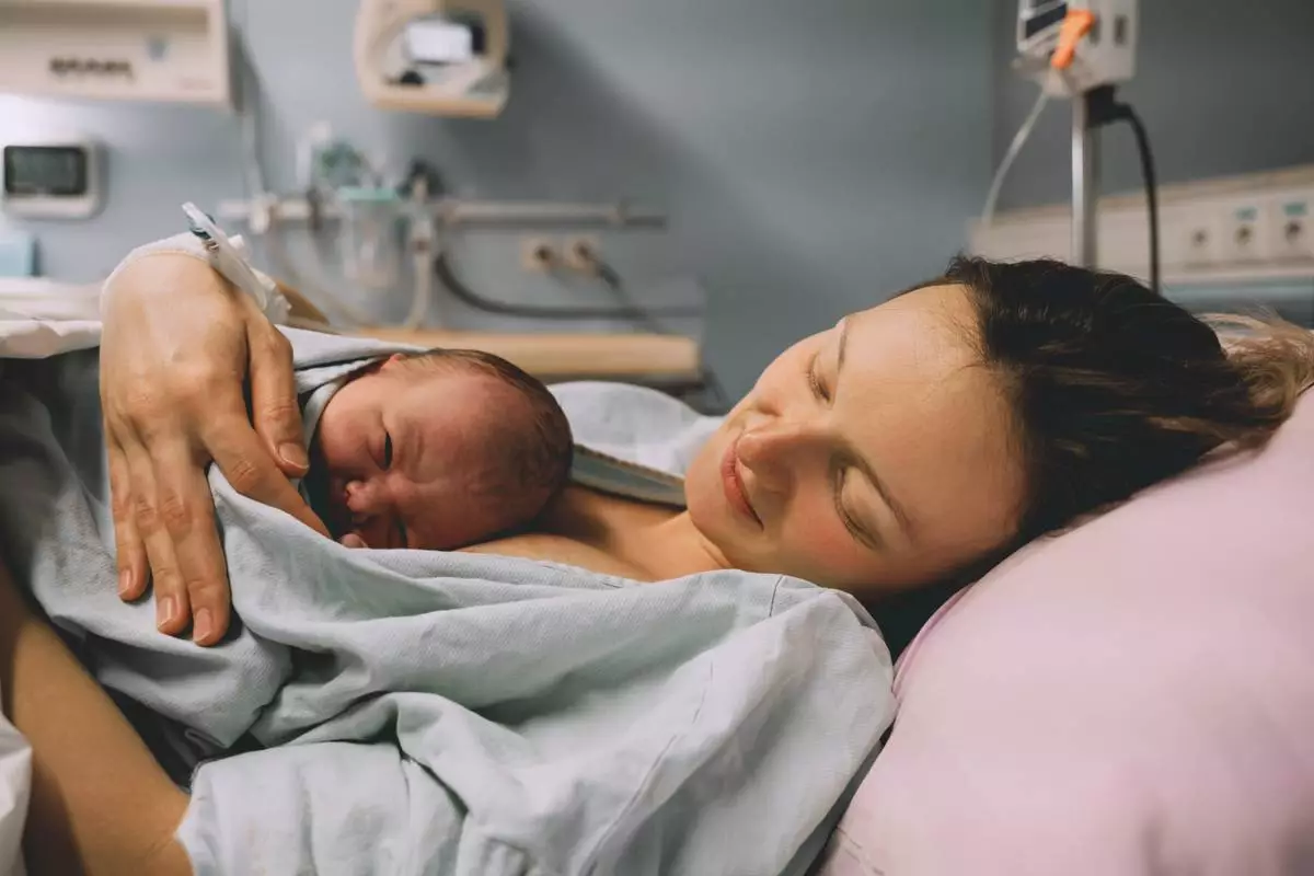 A mother hugging her newborn baby in a hospital shortly after labor and giving birth. (Source: Natalia Deriabina, Shutterstock)
