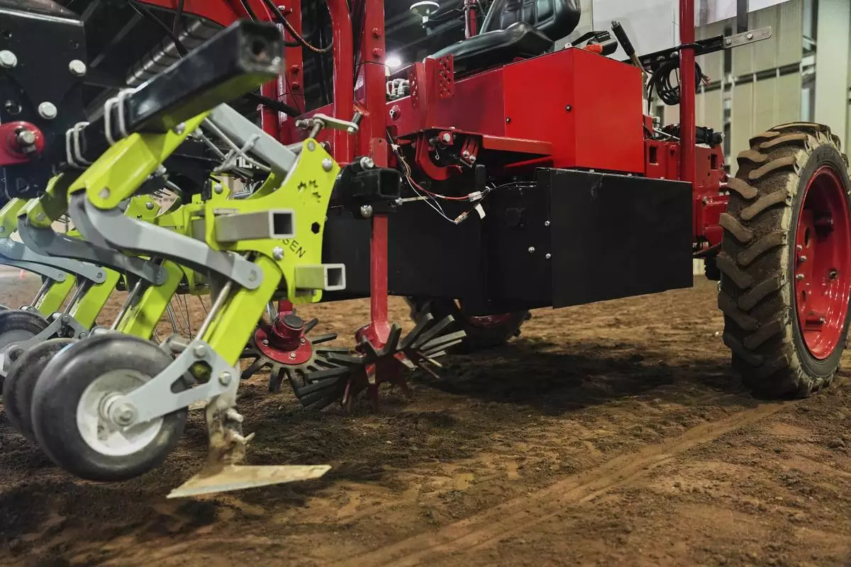 Farm implements, at left, and a battery, are attached to the underside of an electric tractor Tuesday, Aug. 19, 2025, in East Lansing, Mich. (AP Photo/Joshua A. Bickel)