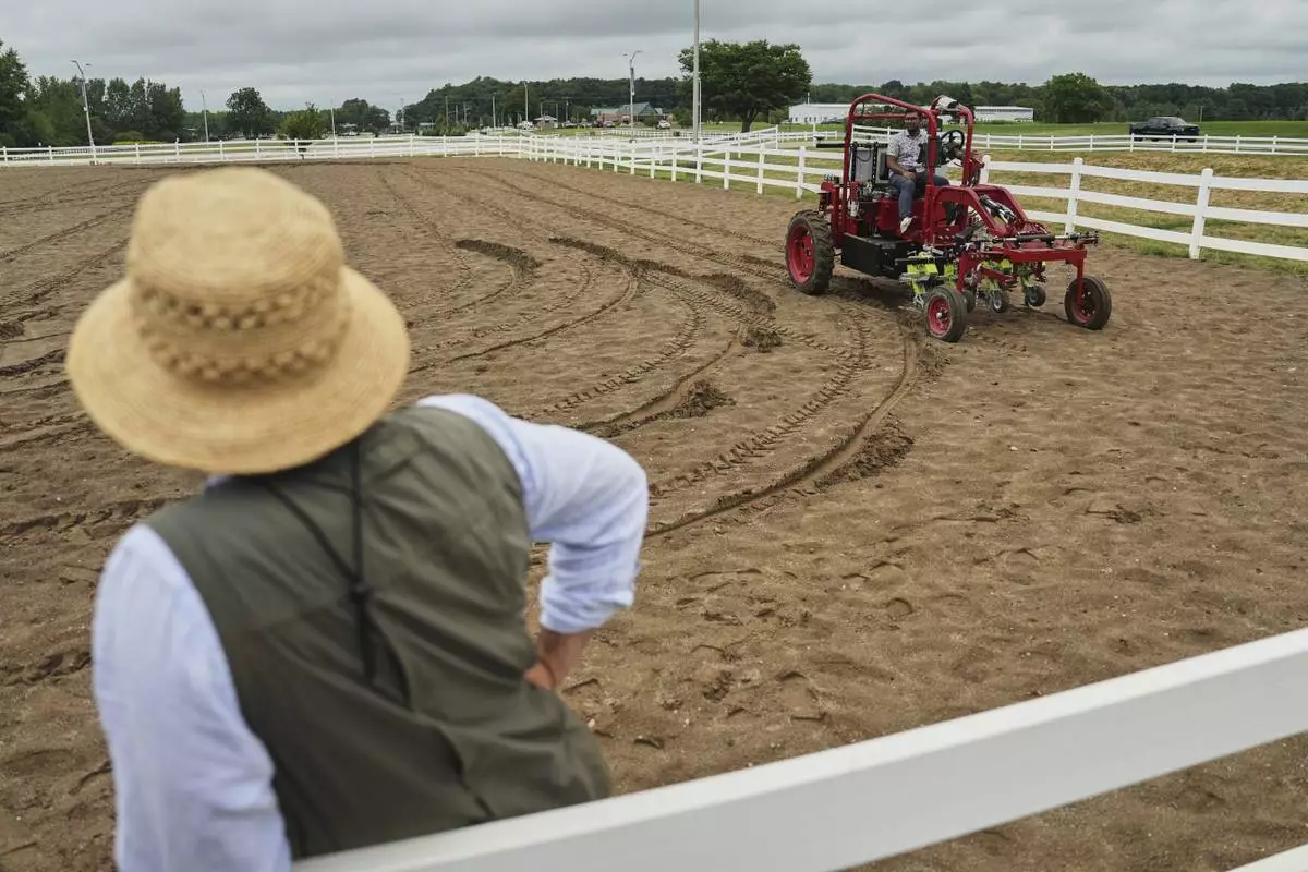 MK Bashar, right, test drives an electric tractor as Ben Phillips, left, watches Tuesday, Aug. 19, 2025, during a demonstration in East Lansing, Mich. (AP Photo/Joshua A. Bickel)