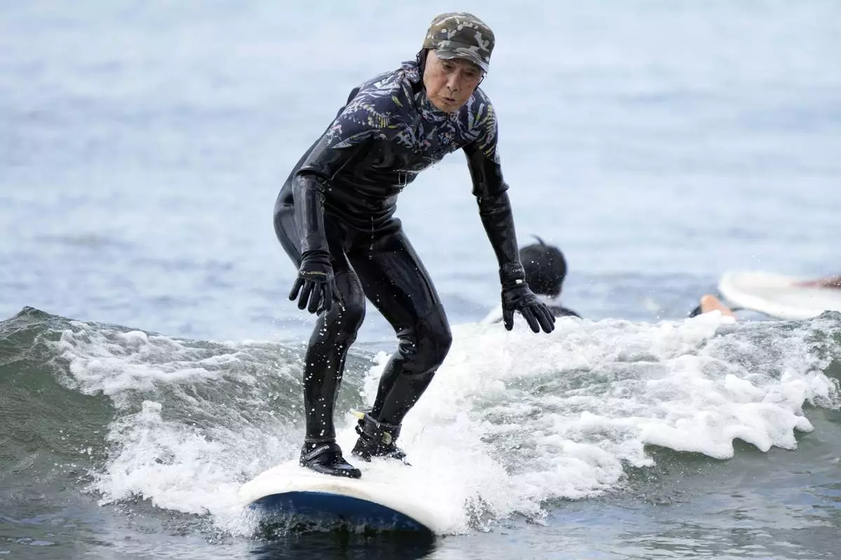 Seiichi Sano, an 89-year-old Japanese man, rides a wave at Katase Nishihama Beach, Thursday, March 30, 2023, in Fujisawa, south of Tokyo. Sano, who turns 90 later this year, has been recognized by the Guinness World Records as the oldest male to surf. (AP Photo/Eugene Hoshiko)