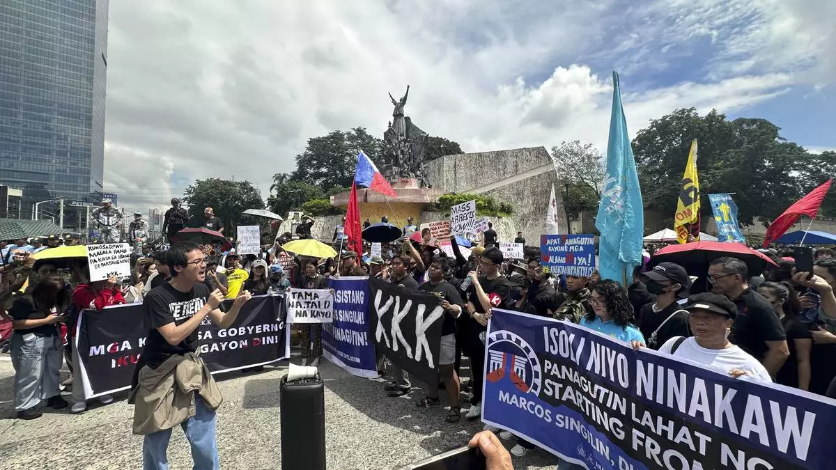 Protesters hold a rally at the People Power Monument in Manila Saturday morning, Sept. 13, 2025, over allegations of massive corruption in flood control projects that have implicated several congressmen and public works officials and sparked pockets of street protests. (AP Photo/Joeal Calupitan)