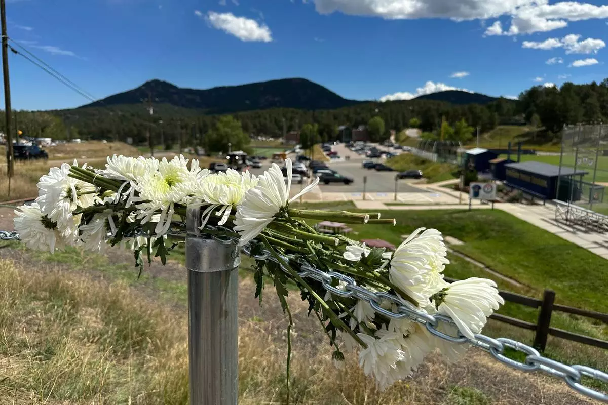 Flowers are left in remembrance of those wounded in a shooting at Evergreen High School in Evergreen, Colo., Thursday, Sept. 11, 2025. (AP Photo/Colleen Slevin)