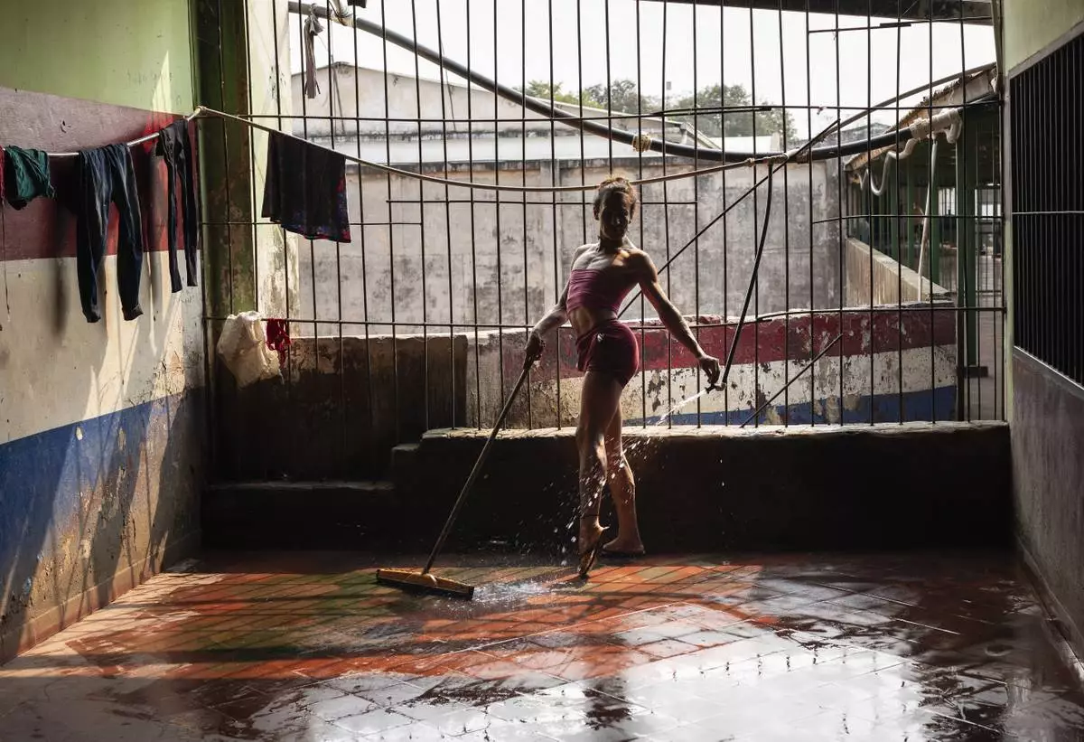 FILE PHOTO GALLERY - Magali Vargas strikes a pose while cleaning the floor of the pavilion reserved for transgender inmates at the Regional Penitentiary in Coronel Oviedo, Paraguay, Aug. 30, 2024. (AP Photo/Rodrigo Abd)
