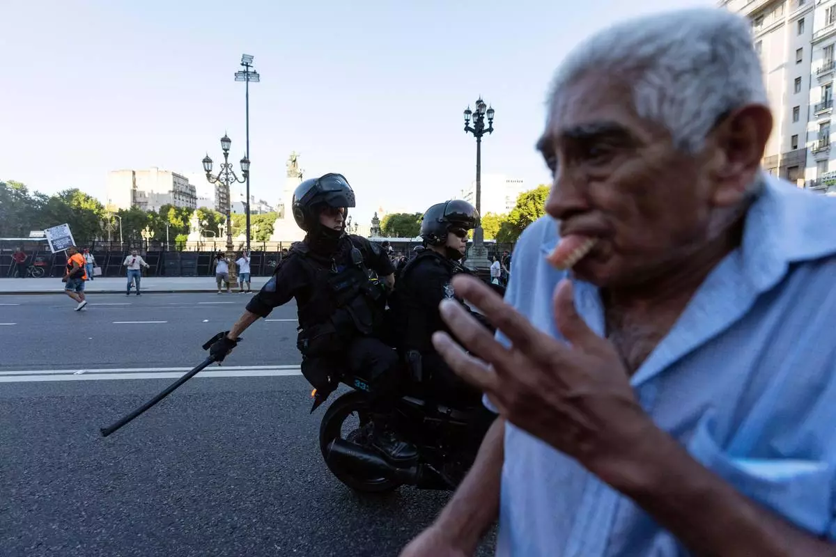 FILE PHOTO GALLERY - A protester’s dentures fly out of his mouth while running for cover as police on motorcycle work to disperse a demonstration of retirees demanding higher pensions, in Buenos Aires, Argentina, March 5, 2025. (AP Photo/Rodrigo Abd)