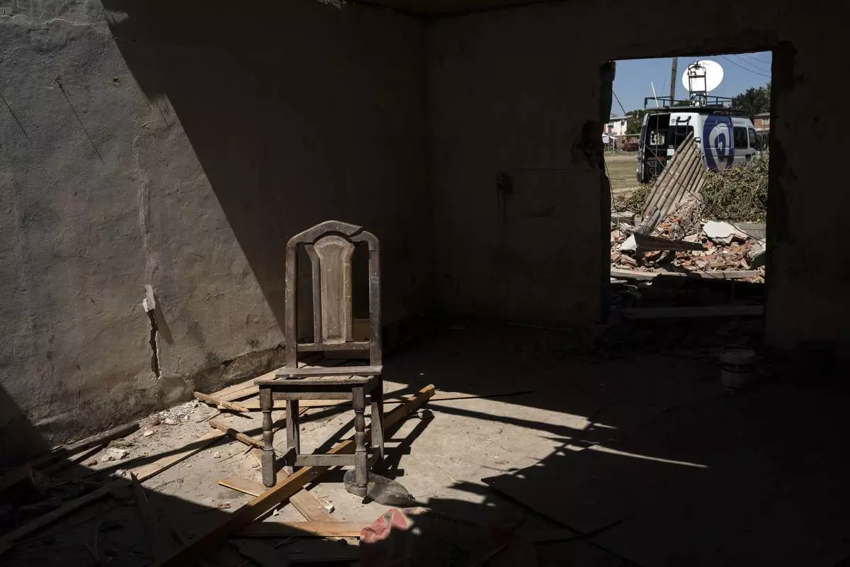 FILE PHOTO GALLERY - A chair sits inside inside a house that residents say is an alleged drugs sales point known as the “Bunker” which was destroyed by neighbors and relatives of an 11-year-old boy who was fatally shot when at least one gunmen attacked a birthday party in Los Pumitas neighborhood of Rosario, Argentina, March 7, 2023. (AP Photo/Rodrigo Abd)