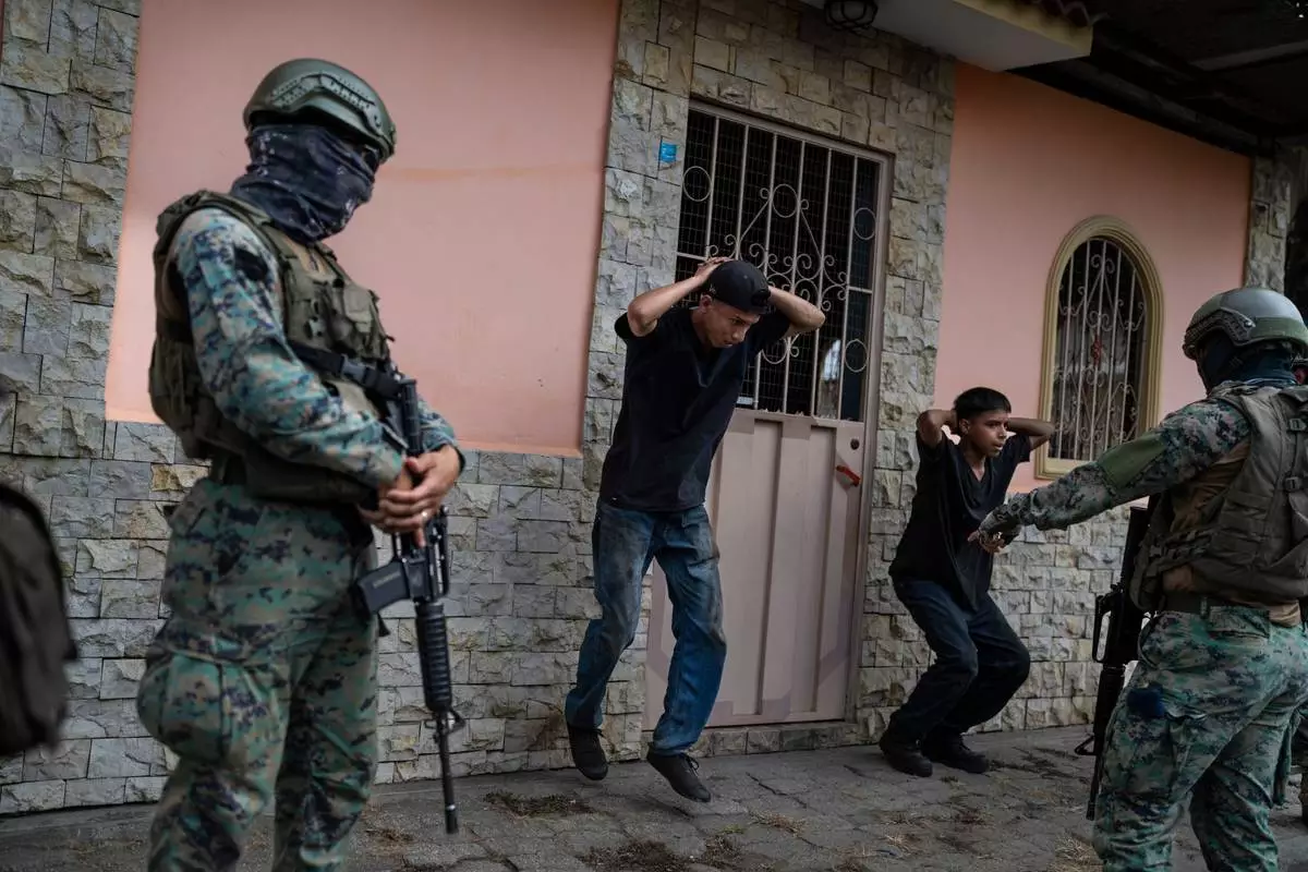 FILE PHOTO GALLERY - Soldiers on patrol force young men into doing squats as punishment for not having the proper documents to circulate their motorcycle, in Duran, Ecuador, Sept. 30, 2023. (AP Photo/Rodrigo Abd)