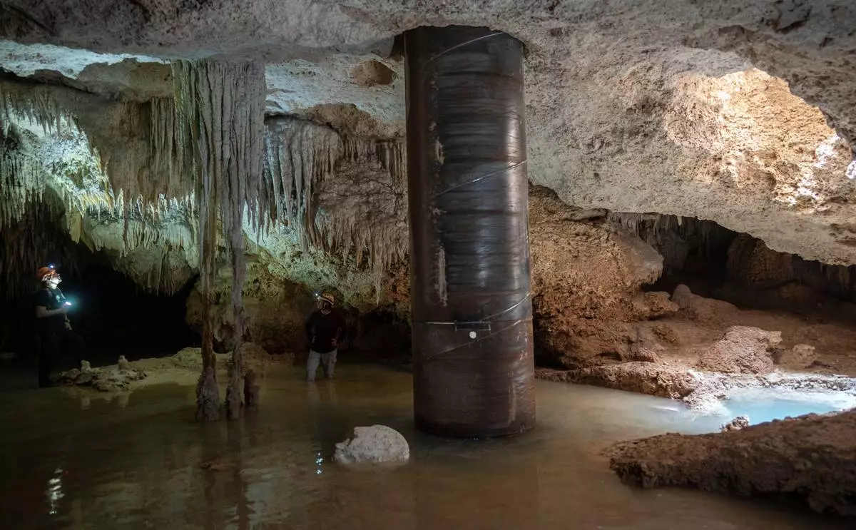 FILE PHOTO GALLERY - Biologist Roberto Rojo, left, observes stalactites near a steel pillar filled with concrete that was installed inside the Aktun Tuyul cave system to support the Maya Train track, on the outskirts of Playa del Carmen, Mexico, March 8, 2024. (AP Photo/Rodrigo Abd)