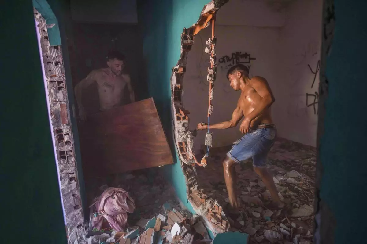 FILE PHOTO GALLERY - Neighbors and relatives of an 11-year-old boy who was fatally shot during a birthday party, destroy the home of the suspected gunman amid anger over escalating drug violence in Los Pumitas neighborhood of Rosario, Argentina, March 6, 2023. (AP Photo/Rodrigo Abd)