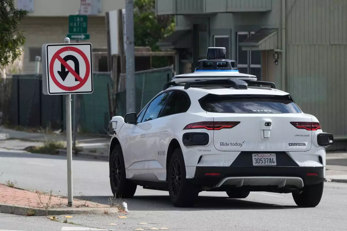 A Waymo vehicle drives past a No U-Turn sign in San Bruno, Calif., Tuesday, Sept. 30, 2025. (AP Photo/Jeff Chiu)