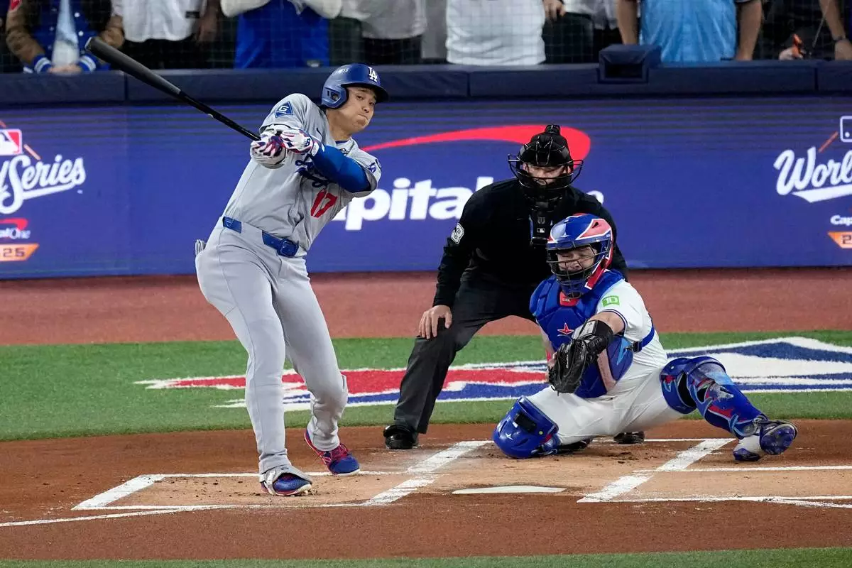 Los Angeles Dodgers' Shohei Ohtani strikes out during the first inning in Game 1 of baseball's World Series against the Toronto Blue Jays, Friday, Oct. 24, 2025, in Toronto. (AP Photo/David J. Phillip)