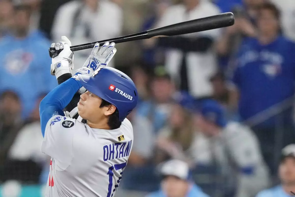 Los Angeles Dodgers' Shohei Ohtani (17) hits a two-run home run against the Toronto Blue Jays during the sixth inning in Game 1 of baseball's World Series, Friday, Oct. 24, 2025, in Toronto. (Nathan Denette/The Canadian Press via AP)