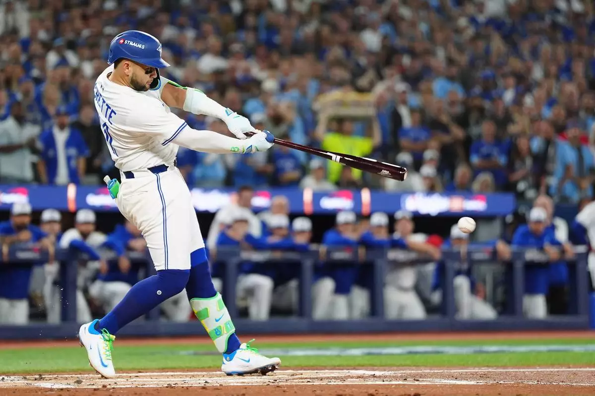 Toronto Blue Jays' Bo Bichette hits a single against the Los Angeles Dodgers during the first inning of Game 1 of baseball's World Series, Friday, Oct. 24, 2025, in Toronto. (Frank Gunn/The Canadian Press via AP)