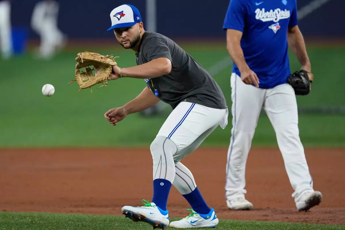 Toronto Blue Jays' Bo Bichette fields a ball during a World Series baseball media day, Thursday, Oct. 23, 2025, in Toronto. The Toronto Blue Jays face the Los Angeles Dodgers in Game 1 on Friday. (AP Photo/David J. Phillip)