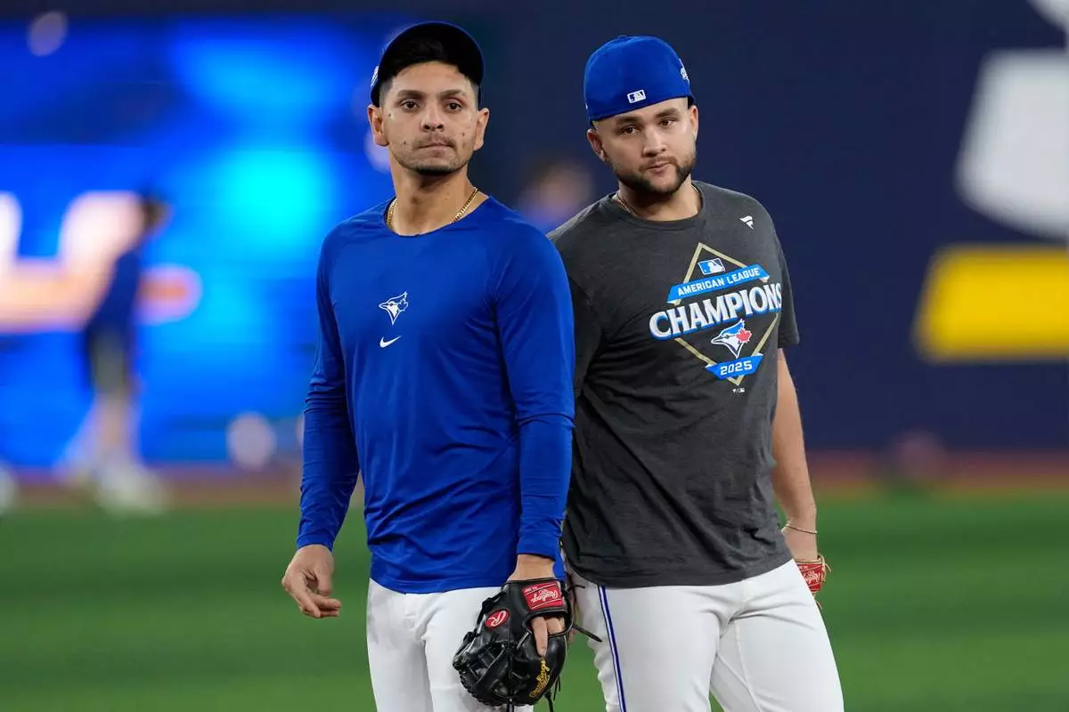 Toronto Blue Jays' Andrés Giménez, left, and Bo Bichette run drills during a World Series baseball media day, Thursday, Oct. 23, 2025, in Toronto. The Toronto Blue Jays face the Los Angeles Dodgers in Game 1 on Friday. (AP Photo/David J. Phillip)