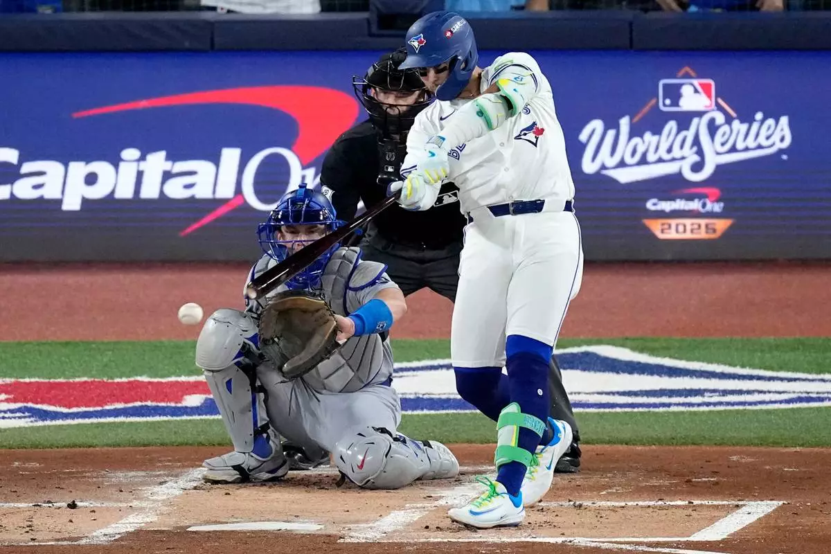 Toronto Blue Jays' Bo Bichette connects for a base hit against the Los Angeles Dodgers during the first inning in Game 1 of baseball's World Series, Friday, Oct. 24, 2025, in Toronto. (AP Photo/David J. Phillip)