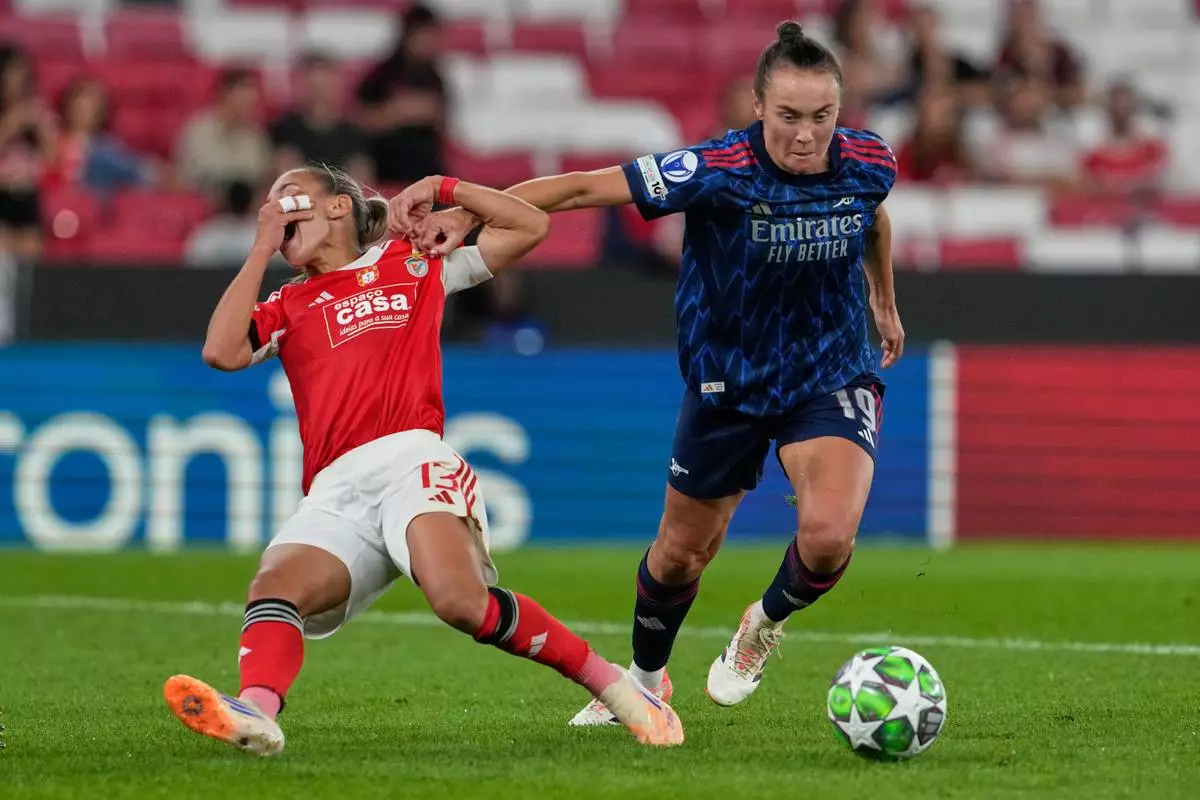 Arsenal's Caitlin Foord, right, challenges for the ball with Benfica's Lucia Alves during the women's Champions League opening phase soccer match between SL Benfica and Arsenal at the Luz Stadium, in Lisbon, Portugal, Thursday, Oct. 16, 2025. (AP Photo/Armando Franca)