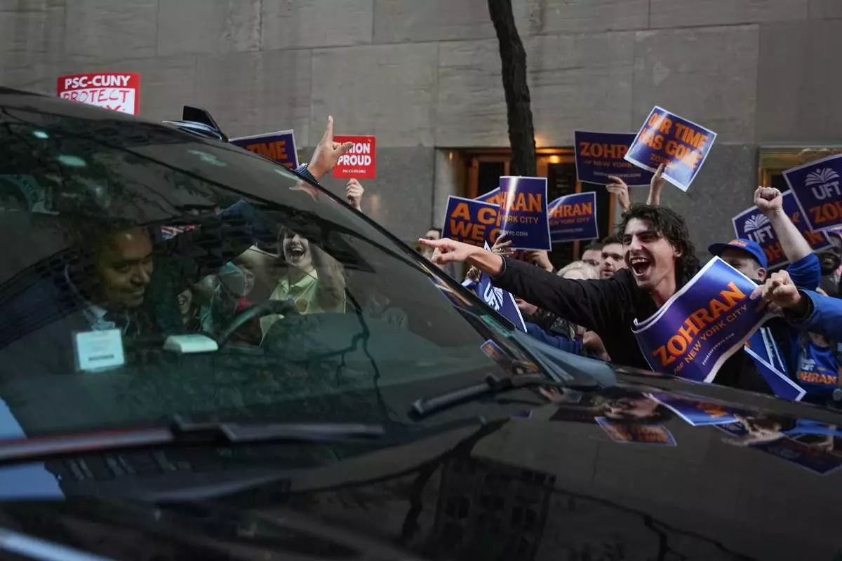 Supporters for Democratic candidate Zohran Mamdani react as a car passes outside NBC Studios before a mayoral debate, Thursday, Oct. 16, 2025, in New York. (AP Photo/Angelina Katsanis)