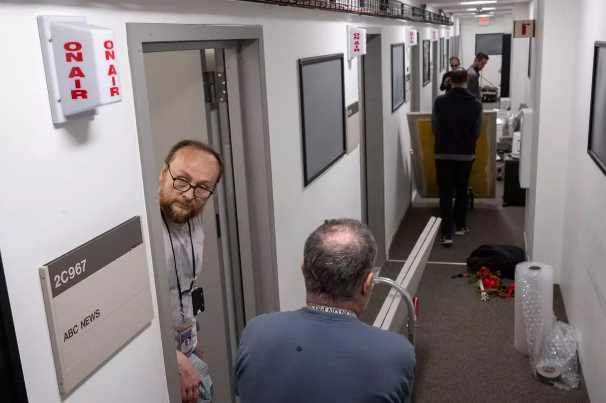 Members of the media pack up their belongings in the press area of the Pentagon, Wednesday, Oct. 15, 2025 in Washington. (AP Photo/Kevin Wolf)