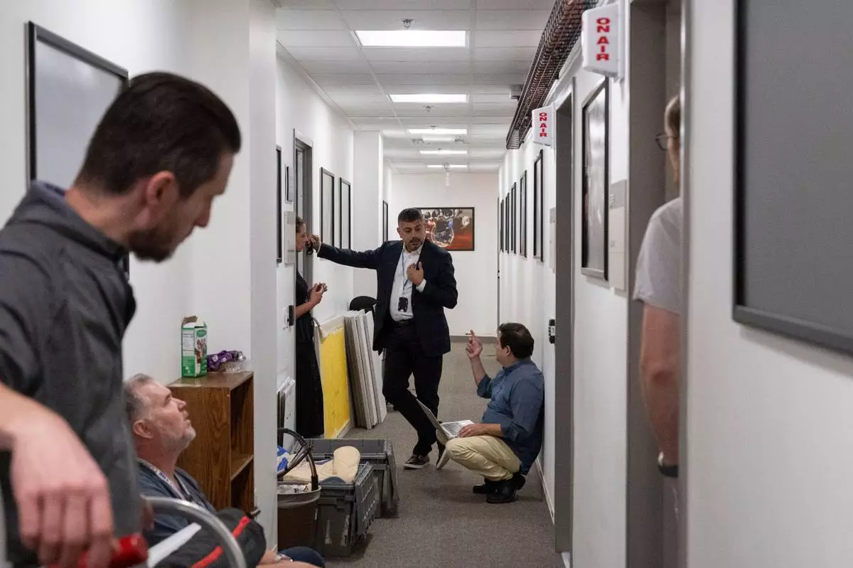 Members of the media pack up their belongings in the press area of the Pentagon, Wednesday, Oct. 15, 2025 in Washington. (AP Photo/Kevin Wolf)