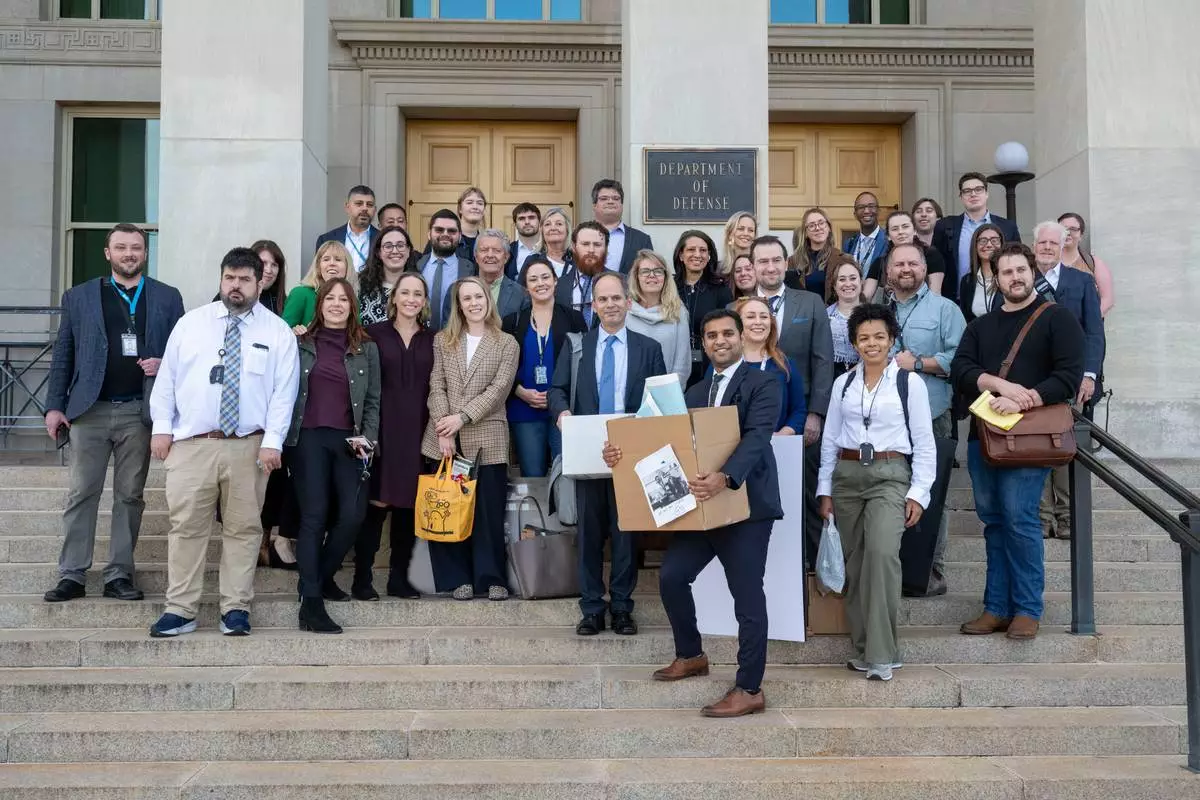 Members of the Pentagon press corp gather for a group photo after turning in their press credentials, Wednesday, Oct. 15, 2025 in Washington. (AP Photo/Kevin Wolf)
