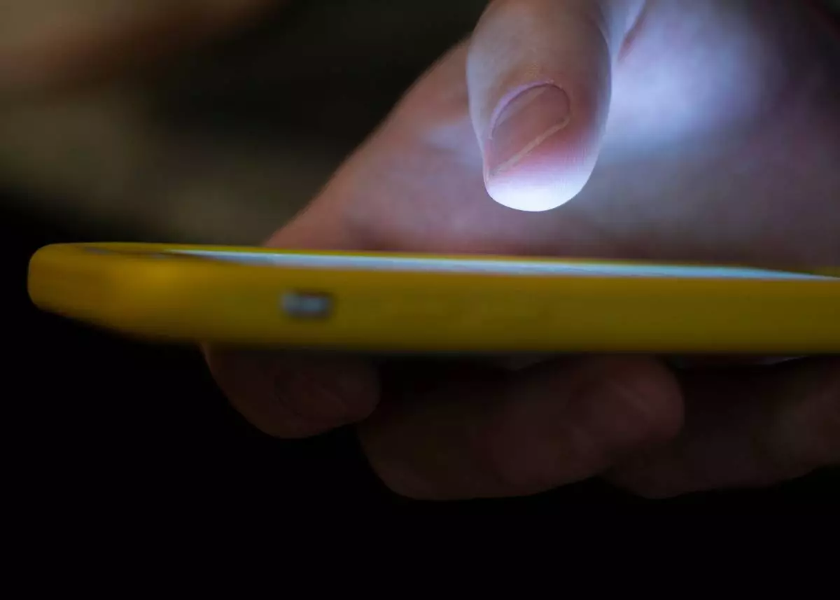 FILE - A man uses a cell phone in New Orleans, Aug. 11, 2019. (AP Photo/Jenny Kane, File)