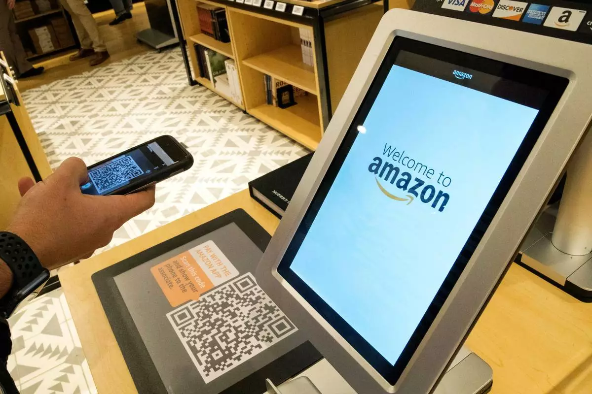 FILE - Daniel Thorpe, of Hoboken, N.J., uses the Amazon app to pay for his purchase at the Amazon 4-star store in the Soho neighborhood of New York, on Sept. 27, 2018. (AP Photo/Mary Altaffer, File)