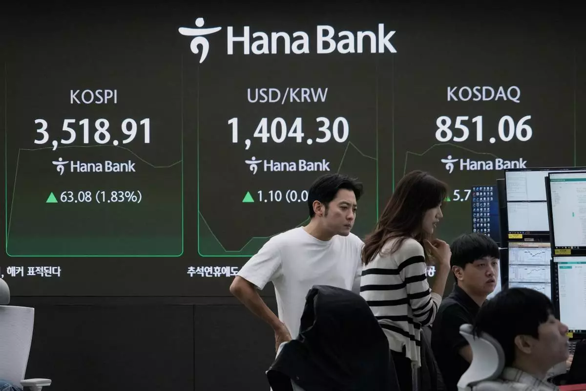 Currency traders watch monitors near a screen showing the Korea Composite Stock Price Index (KOSPI), top left, and the foreign exchange rate between U.S. dollar and South Korean won, top center, at the foreign exchange dealing room of the Hana Bank headquarters in Seoul, South Korea, Thursday, Oct. 2, 2025. (AP Photo/Ahn Young-joon)