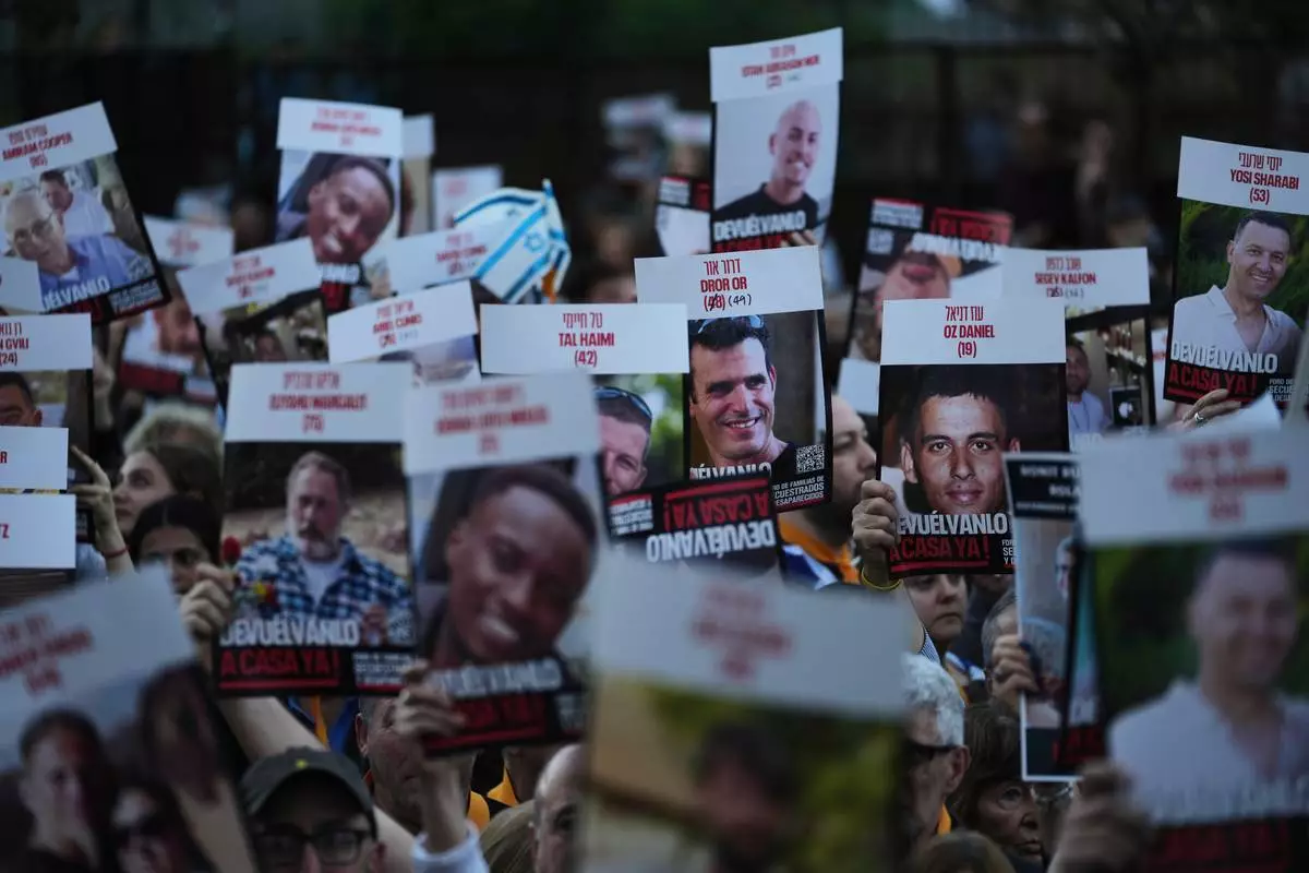 People hold up posters of hostages in Hamas captivity in Gaza, to demand their release, in Buenos Aires, Argentina, Tuesday, Sept. 30, 2025. (AP Photo/Rodrigo Abd)