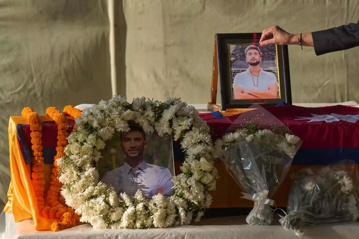 A Nepalese man pays his respects to Bipin Joshi, a Nepali man who was taken hostage by Hamas, during a memorial procession at Tribhuvan International Airport in Kathmandu, Nepal, Monday, Oct. 20, 2025. (AP Photo/Niranjan Shrestha)
