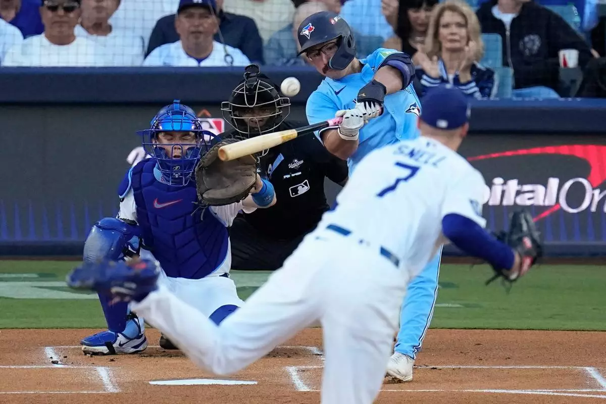 Toronto Blue Jays' Davis Schneider connects for a solo home run off Los Angeles Dodgers pitcher Blake Snell (7) leave the park during the first inning in Game 5 of baseball's World Series, Wednesday, Oct. 29, 2025, in Los Angeles. (AP Photo/David J. Phillip)