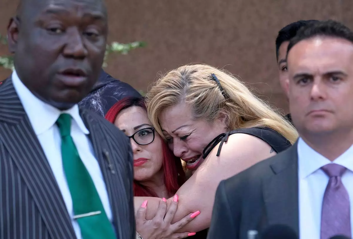 FILE - Nicole Castro cries as she hugs Janet Rameriz behind attorneys Ben Crump, left, and Adam Slater during a press conference with survivors of sexual abuse that occurred at MacLaren Hall, June 9, 2022 in Los Angeles. (Dean Musgrove/The Orange County Register via AP, File)