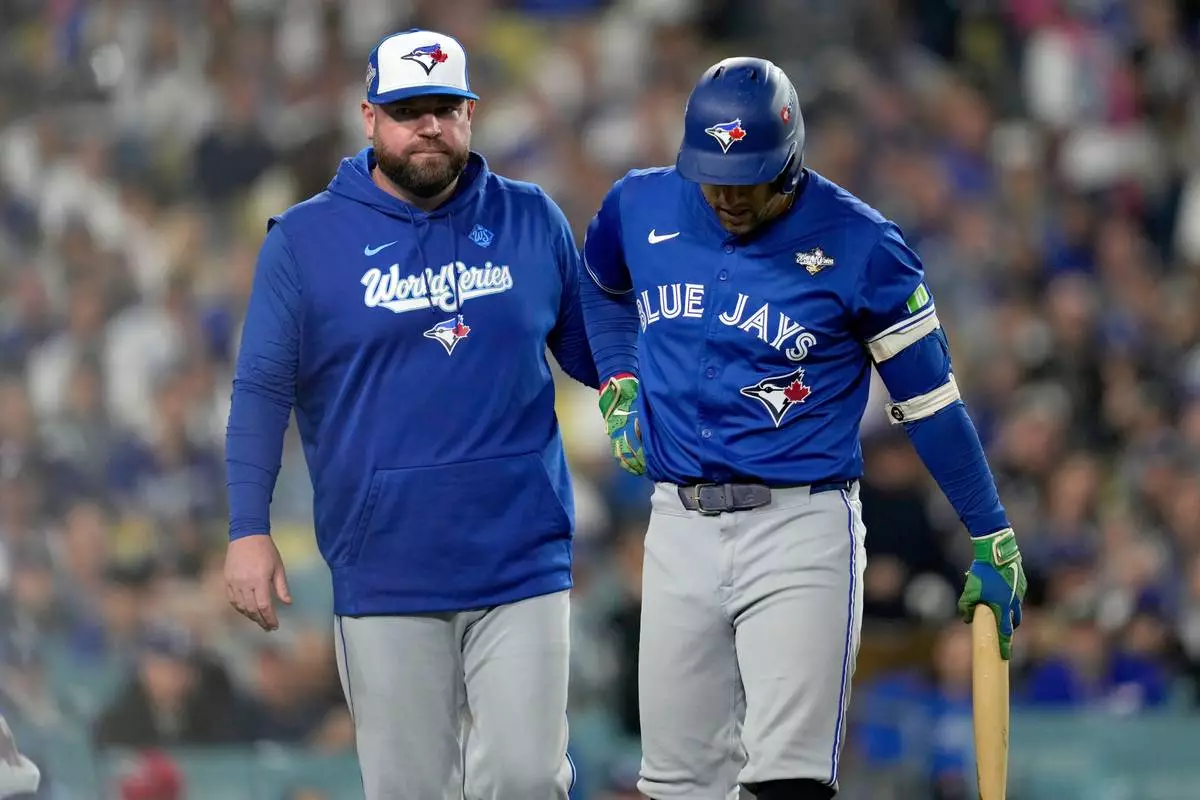 Toronto Blue Jays manager John Schneider helps George Springer off the field with an injury during the seventh inning in Game 3 of baseball's World Series against the Los Angeles Dodgers, Monday, Oct. 27, 2025, in Los Angeles. (AP Photo/Ashley Landis)