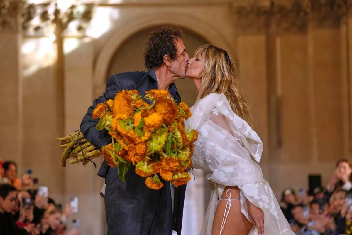 Designer Andreas Kronthaler, left, kisses Heidi Klum after the Vivienne Westwood Spring/Summer 2026 collection presented in Paris, Saturday, Oct. 4, 2025. (AP Photo/Aurelien Morissard)