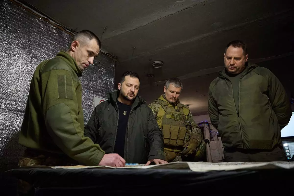 In this photo provided by the Ukrainian Presidential Press Office, Ukrainian President Volodymyr Zelenskyy, 2nd left, looks at a map during his visit to Ukrainian 110th mechanised brigade in Avdiivka, the site of fierce battles with the Russian troops in the Donetsk region, Ukraine, Friday, Dec. 29, 2023. Right is head of the Presidential Office Andriy Yermak; deputy head of the Presidential Office Roman Mashovets is 2nd right. (Ukrainian Presidential Press Office via AP)