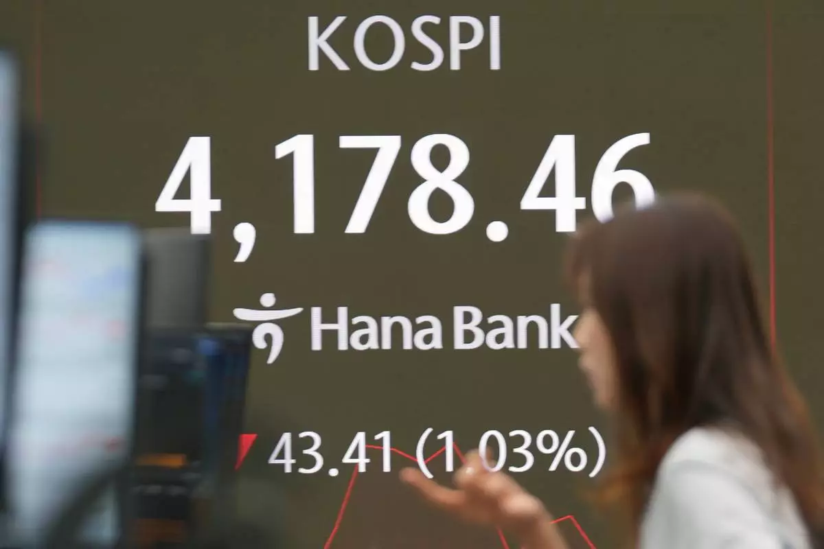 A dealer talks near the screens showing the Korea Composite Stock Price Index (KOSPI) at a dealing room of Hana Bank in Seoul, South Korea, Tuesday, Nov. 4, 2025. (AP Photo/Lee Jin-man)