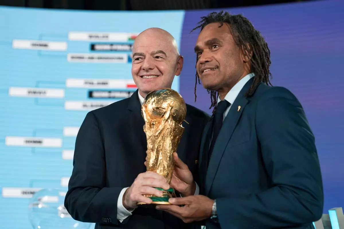 FIFA President Gianni Infantino, left, poses with Christian Karembeu during the FIFA World Cup 2026 playoff draw in Zurich, Switzerland, Thursday, Nov. 20, 2025. (Claudio Thoma/Keystone via AP)