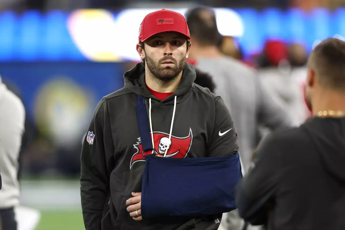 Tampa Bay Buccaneers quarterback Baker Mayfield, 6, wears a sling and watches from the sideline during the second half of an NFL football game against the Los Angeles Rams on Sunday, Nov. 23, 2025, in Inglewood, Calif. (AP Photo/Jesse Arche)