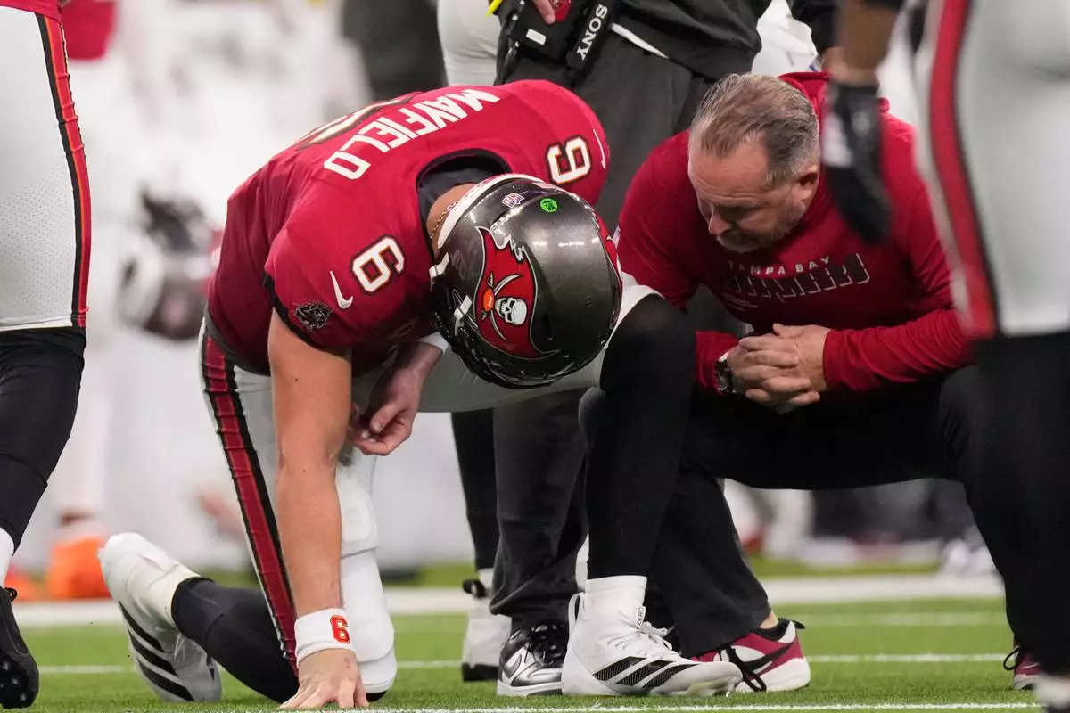 Tampa Bay Buccaneers quarterback Baker Mayfield, 6, reacts with a trainer during the first half of an NFL football game against the Los Angeles Rams on Sunday, Nov. 23, 2025 in Inglewood, Calif. (AP Photo/Mark J. Terrill)