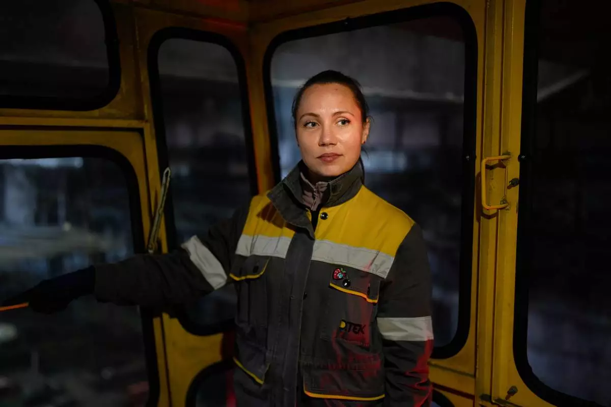 Maria, 35, a bridge crane operator, who declined to give her surname due to security concerns, poses for a portrait at a Ukrainian thermal power plant, Wednesday, Oct. 29, 2025. Her heart sinks anytime she hears missiles overhead, praying they don't hit her plant. “And then you hear explosions and realize they probably have (hit),” she says. “You feel anxious — not for yourself, but for what we do, for our work.” (AP Photo/Julia Demaree Nikhinson)
